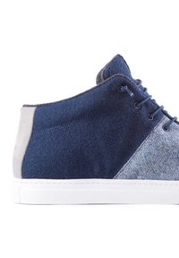 Półwysoki sneakers z ciemnoniebieskiego filcu i jasnoszarego zamszu, z białą gumową podeszwą i wiązanym designem.