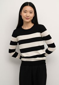 Black and cream striped sweater with long sleeves and a round neckline. Knit fabric with a ribbed hem and cuffs, fitted silhouette.