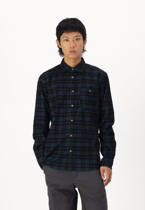 Black and blue plaid button-up shirt with a collar, single chest pocket, and metal buttons. Made of a smooth fabric with a soft texture.