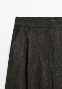 Donkergrijze stofbroek met textuur, voorzien van zijzakken en een tailleband, gelabeld Massimo Dutti.