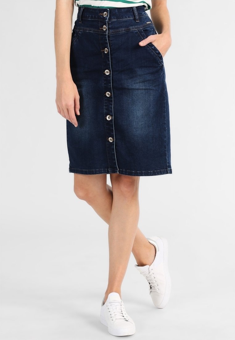 Džínová sukně v tmavě modré barvě, ke kolenům, s předním zapínáním na velké stříbrné knoflíky, bočními kapsami a mírně přiléhavým střihem.