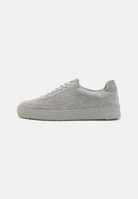 Sneaker in suede grigio con profilo basso, punta rotonda, sei occhielli e una suola in gomma leggermente strutturata. Branding sottile sul tallone.