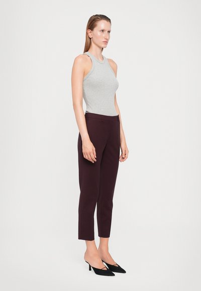 Hall sügavate ribidega tank top, tumesinised keha lähedal püksid, mustad terava ninaga kontsad. Puhtad jooned ja korralik siluett. Siledad tekstuurid kogu ulatuses.