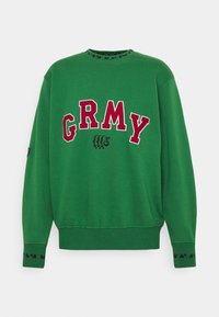 Felpa verde con la scritta "GRMY" in bold lettere rosse, colletto e polsini a costine con dettagli neri, design a vestibilità rilassata.