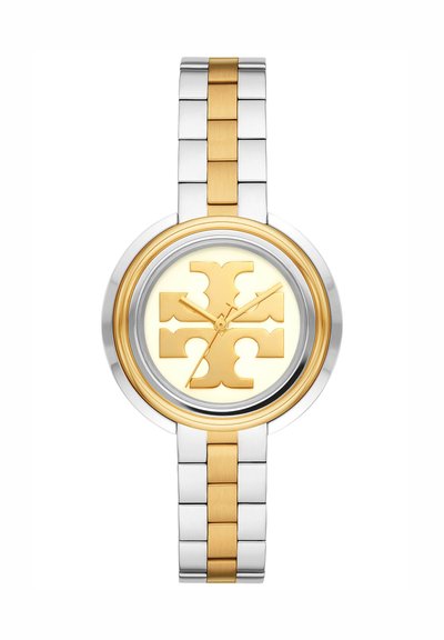 Orologio da polso bicolore argento e oro con quadrante rotondo, lancette dorate per ore e minuti e un grande emblema decorativo dorato sul quadrante.