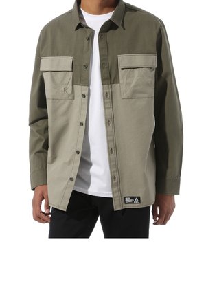 Veste chemise vert olive clair avec deux poches poitrine, fermeture à boutons et panneaux contrastants de couleur vert foncé sur la partie supérieure. Tissu en mélange de coton.