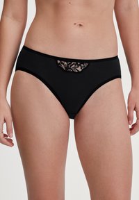Zwarte katoenen slipjes met een bloemkant overlay aan de voorkant van de taille. Heeft een gladde textuur en een elastische tailleband.