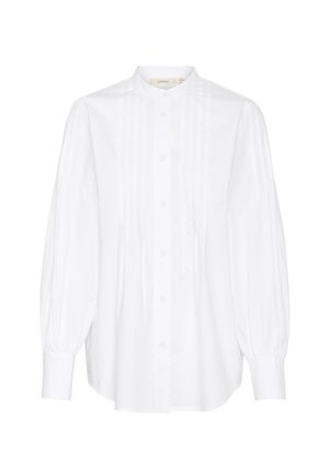 Camicia bianca con collo in piedi, dotata di maniche lunghe e puffate, pieghe verticali sul davanti e orlo arrotondato.