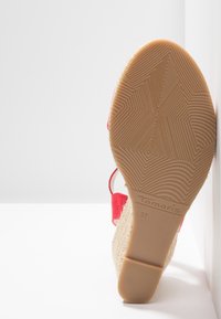 Červená wedge sandál s texturovanou espadrilovou podrážkou. Obsahuje korkovou texturu a logo detail na podrážce. Velikost 37.
