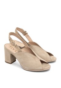 Cizme slingback din suede bej, cu toc bloc, design cu degetele deschise, curea ajustabilă și textură netedă. Prezintă un logo subtil pe branț.
