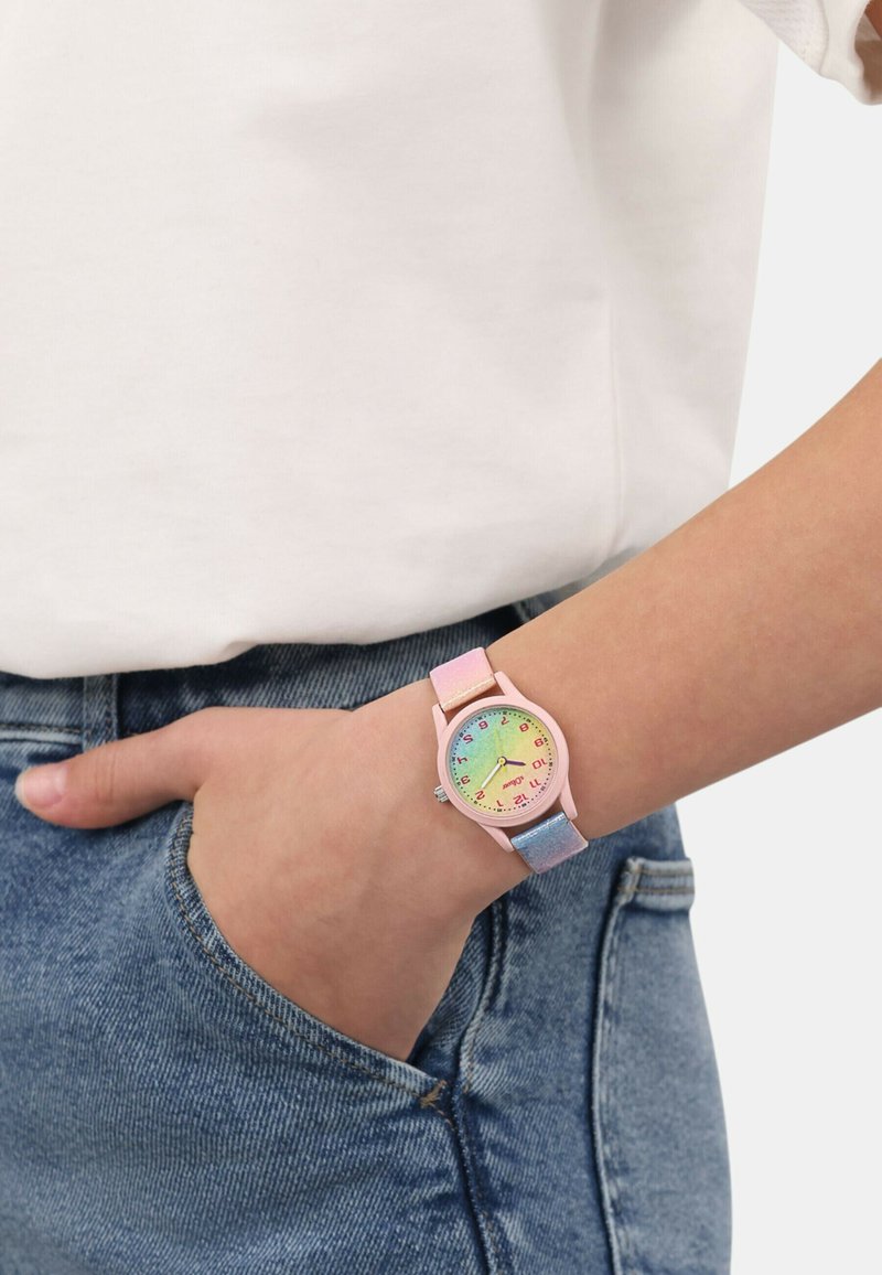 Kinderuhr mit einem pastellpinken Kunststoffgehäuse, Zifferblatt mit Regenbogenverlauf, bunten Stundenmarkierungen und einem mehrfarbigen Armband.