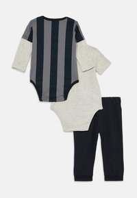 Three-piece baby outfit: one striped long-sleeve bodysuit in navy and gray, one gray short-sleeve bodysuit, and navy pants. Soft cotton material.