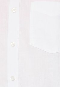 Camisa blanca hecha de una tela ligera que presenta un bolsillo puntiagudo, botones visibles y un patrón de tejido texturizado.
