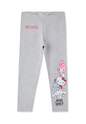 Leggings grigi chiari con il testo "Hello Kitty e Amici" sulla coscia sinistra e personaggi dei cartoni animati che tengono regali impilati sulla parte bassa della gamba destra.