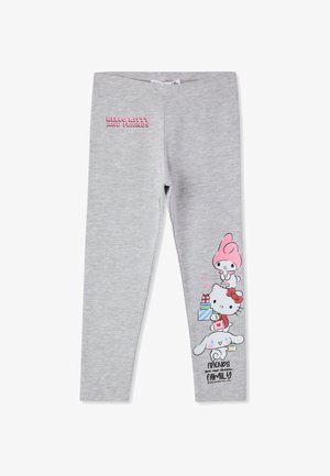 Leggings grigi chiari con il testo "Hello Kitty e Amici" sulla coscia sinistra e personaggi dei cartoni animati che tengono regali impilati sulla parte bassa della gamba destra.