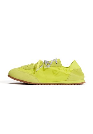 Low-profile felgele sneaker met rubberen zool, suède neus en hiel, zilveren veters en elastische achterkraag voor een stevige pasvorm.