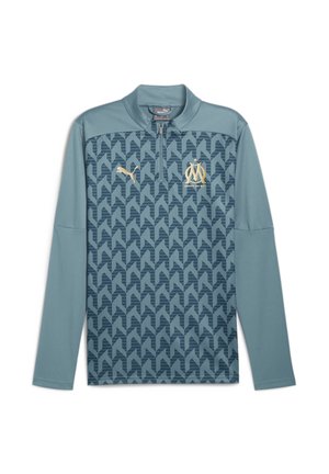Puma ilgām piedurknēm sporta krekls teal krāsā, ar ģeometrisku rakstu, pus-zipsa apkakli un zeltītām logotipa akcentiem uz krūtīm un piedurknēm.