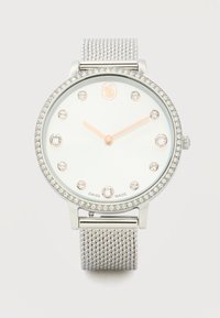 Στρογγυλό ασημένιο ρολόι με στεφάνη διακοσμημένη με κρύσταλλα, μπάντα από πλέγμα, λευκό καντράν, δείκτες ώρας από κρύσταλλα και χρυσούς δείκτες που δείχνουν 10:10.