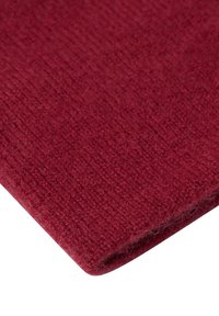 Burgundy neulekangas, jossa on pehmeä, rakenteellinen pinta. Kuvassa näkyy läheltä materiaalin kudonta ja lievä karheus reunoilla.