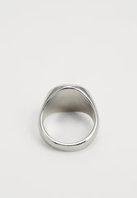Anillo de metal plateado con una superficie lisa y pulida y un diseño redondeado y cónico. El interior es redondeado para mayor comodidad.
