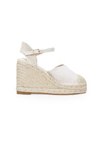 Sandale espadrille à semelle compensée en tissu crème avec une semelle en jute tressé. Elle présente une bride de cheville avec un détail à carreaux et un design de bout arrondi.