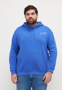 Felpa blu realizzata in tessuto morbido, con tasca frontale, cappuccio con cordino regolabile e logo bianco sul lato sinistro del petto.