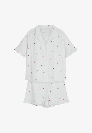 Biały komplet piżamowy z lekkiego materiału, składający się z koszuli na guziki z krótkimi rękawami oraz szortów z czerwonymi wzorami w kształcie serc i falbankowymi wykończeniami.