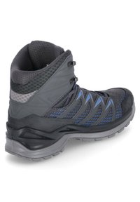 Mid-Cut-Wanderschuh in Schwarz und Grau, mit atmungsaktivem Obermaterial aus Mesh und blauen Akzenten, robuster Gummisohle und Schnürverschluss für zusätzlichen Halt.