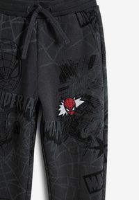 Harmaat verkkarit, joissa on Spider-Man -graafinen printti ja kirjailtu Spider-Man -symboli. Joustava vyötärö, jossa on kiristyksen yksityiskohta.