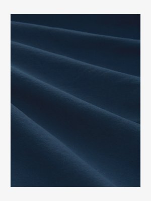 Zacht marineblauwe stof met zachte plooien die gladde, parallelle rimpels creëren, waardoor de textuur en diepte worden benadrukt.