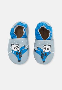 Zapatos de cuero para todoterreno en azul claro con un diseño de panda vestido de azul, con una abertura elástica azul y textura suave.