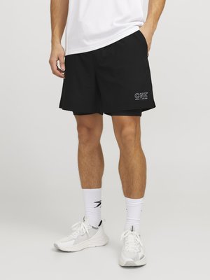 Svarta träningsshorts i lätt material, med en broderad vit "CNZ"-logotyp på vänster lår och sidfickor.
