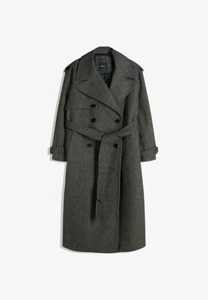 Trench coat lung, din amestec de lână gri, cu un design cu două rânduri de nasturi, rever larg și un cordon propriu. Are epoleți cu nasturi pe umeri și curele la manșete.