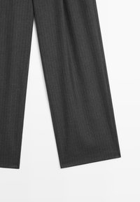 Gray pinstriped trousers made of textured fabric; features wide legs and a tailored design, with vertical stripes and clean hems.
