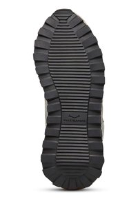 Zool van een sneaker met een zwarte rubberen oppervlakte, met een diep, geribbeld profiel en een ingezegeld logo "VOILE BLANCHE."