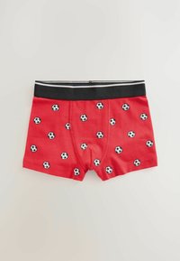 Röda bomullsboxershorts med svart midjeband, som har ett upprepat mönster av små svartvita fotbollar. Slät textur.