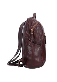 Zaino in pelle marrone con una texture liscia, dotato di una tasca frontale con zip, tasca laterale a scomparsa e spallacci regolabili. Forma curva.