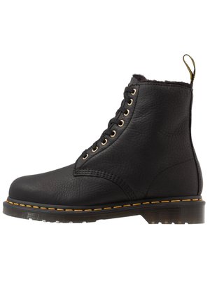 Black leather lace-up boot with yellow stitching, thick sole, and pull tab at the heel, shown in profile on a white background.