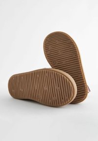 Rubberen zool met een textuurpatroon, bruine kleur, met horizontale en verticale groeven voor grip en tractie.