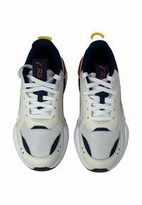 Scarpe sportive bianche con accenti blu navy, materiale in rete e sintetico, chiusura con lacci, collarino imbottito, logo rosso sulla linguetta e suola texturizzata.