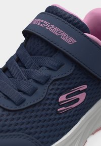 Σκούρο μπλε και ροζ αθλητικό παπούτσι Skechers με υφασμάτινο δίχτυ, κορδόνια και λουράκι με βέλκρο σε λευκή σόλα.