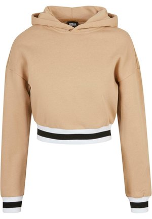 Kuttet hettegenser i lys beige, laget av mykt stoff. Har hette og kontrasterende hvite og svarte striper på kanten og håndleddene.