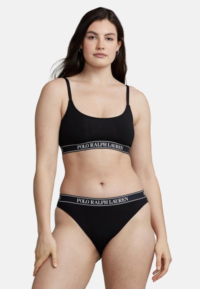 Black bralette and matching bikini with a logoed elastic band. The fabric is smooth, with narrow straps and a basic design.
