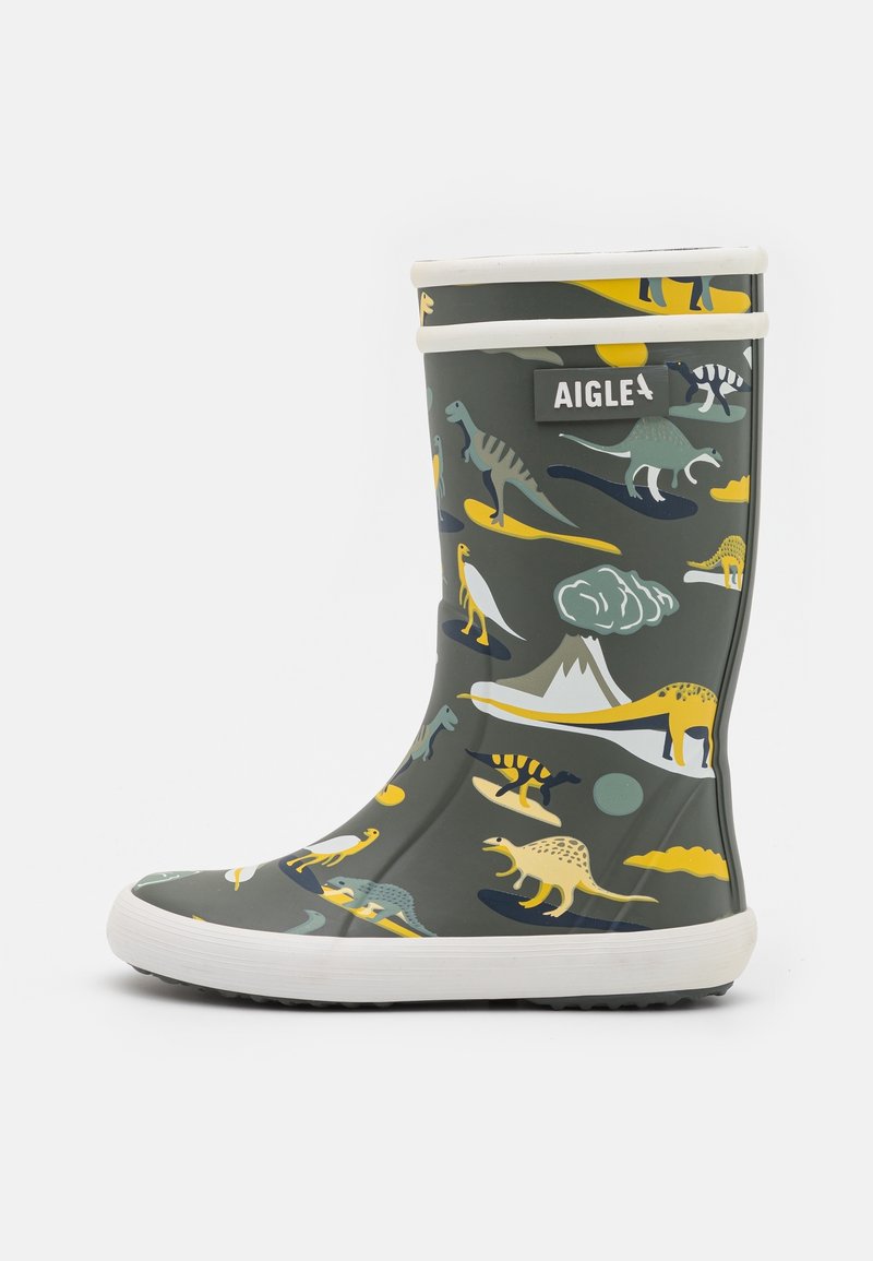 Botte de pluie vert foncé pour enfants avec des motifs colorés de dinosaures et de volcans, semelle blanche, et étiquette de la marque Aigle sur le côté supérieur.