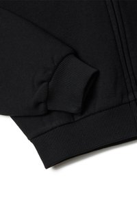 Sudadera negra con puños y dobladillo acanalados, textura suave y cierre frontal con cremallera. El tejido parece duradero y tiene un acabado suave.