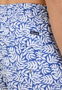 Blauwe shorts met een wit bladenpatroon, elastische tailleband en een achterzak met een merklabel en metalen drukknoopdetail.