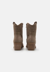 Botas de tobillo de ante marrón con diseño perforado, cremalleras traseras y tacón apilado. Superficie texturizada y puntera redonda.