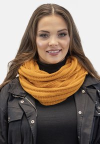 Knitted, circular scarf in a bright mustard color, featuring textured, ribbed patterns. Worn over a black top and jacket.