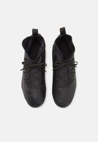 Baskets de sport noires avec une surface lisse et texturée. Présentent un design à découpe basse, un bout rond et des lacets plats. Incluent des languettes pour un enfilage facile.