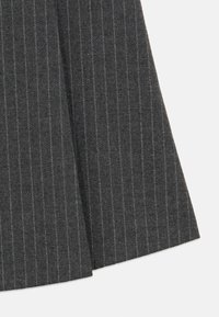 Γκρι ύφασμα από μαλλί με στενές κάθετες λεπτές ρίγες σε ανοιχτό γαλάζιο. Το υλικό έχει απαλή υφή και πέφτει σε ένα ραμμένο σχήμα.